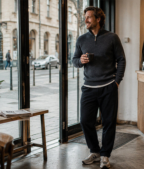 Man wearing a KAMA merino sweater walking his dog.