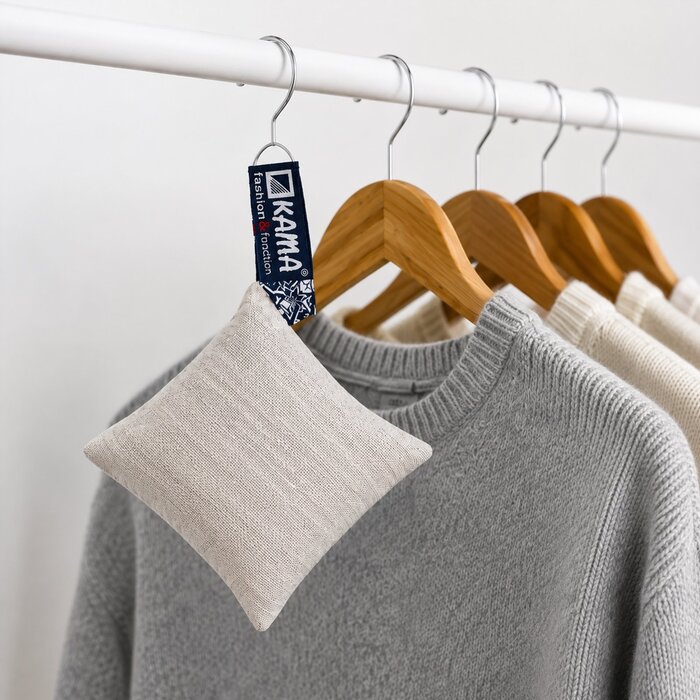 KAMA lavender sachet hanging between merino sweaters in a wardrobe